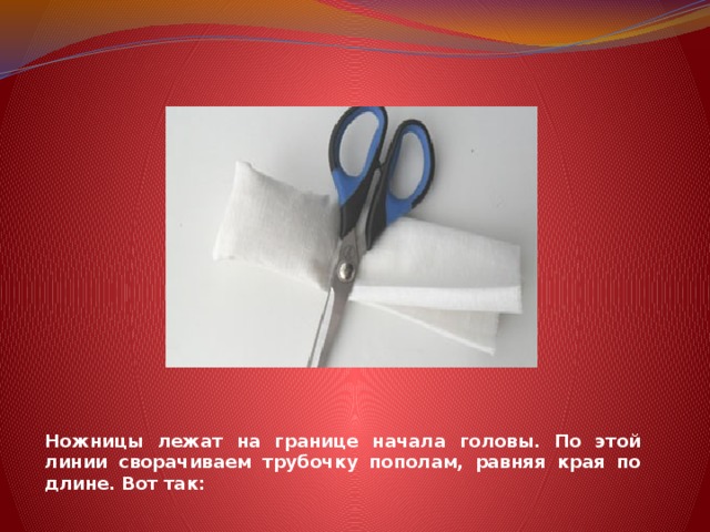 Ножницы лежат на границе начала головы. По этой линии сворачиваем трубочку пополам, равняя края по длине. Вот так: 