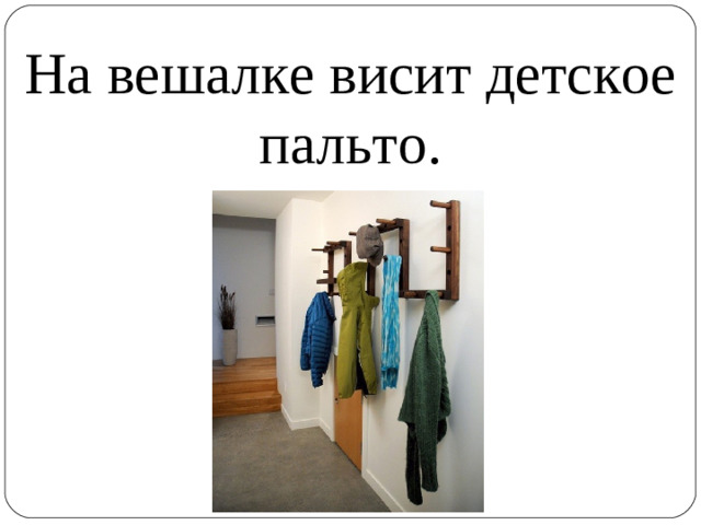 На вешалке висит детское пальто.