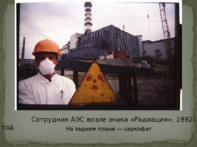 Сотрудник АЭС возле знака «Радиация», 1992 год  На заднем плане — саркофаг
