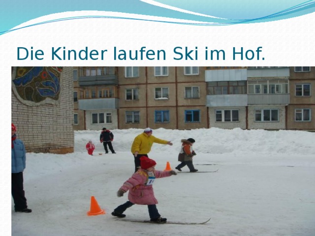 Die Kinder laufen Ski im Hof.